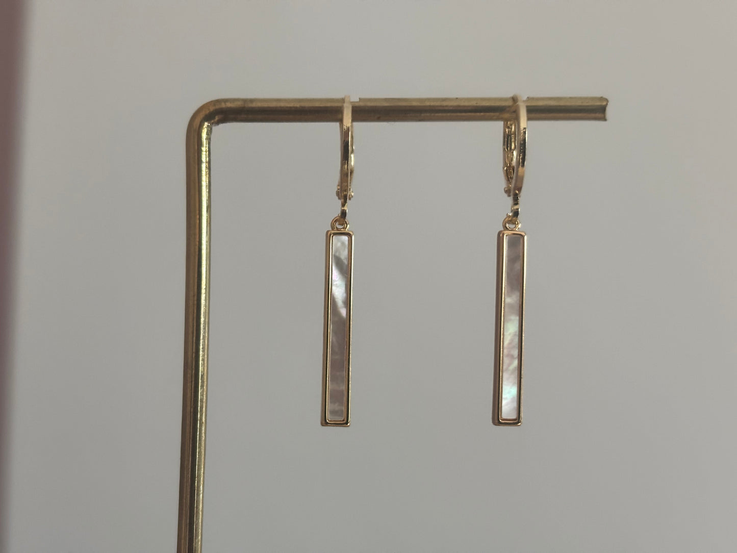 Korte 14k vergulde oorbel met shell staafje, circa 3 cm lang.