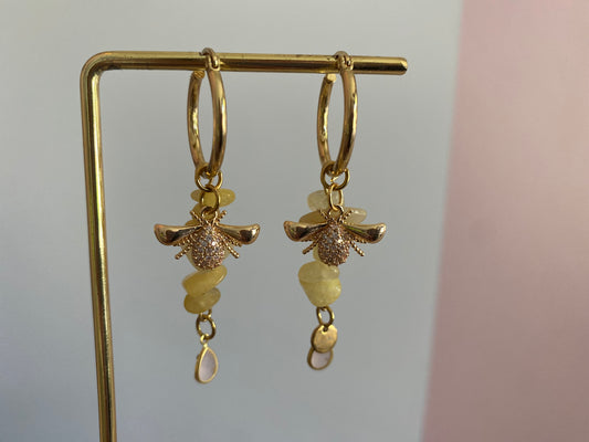 Handgemaakte hoogwaardige oorbellen met RVS hoops en gele natuurstenen hangers met een 18K verguld en zirkonia bijenbedel met onderaan natuurstenen zachtroze bedeltjes.