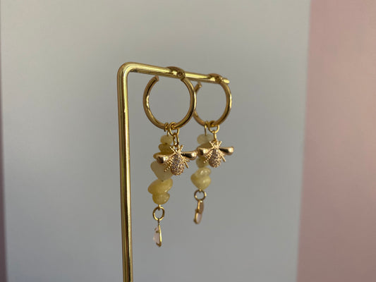 Handgemaakte hoogwaardige oorbellen met RVS hoops en gele natuurstenen hangers met een 18K verguld en zirkonia bijenbedel met onderaan natuurstenen zachtroze bedeltjes.