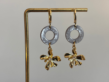 14K vergulde oorbellen met een ronde Polaris hanger en een gouden bloemetje met zirkonia.