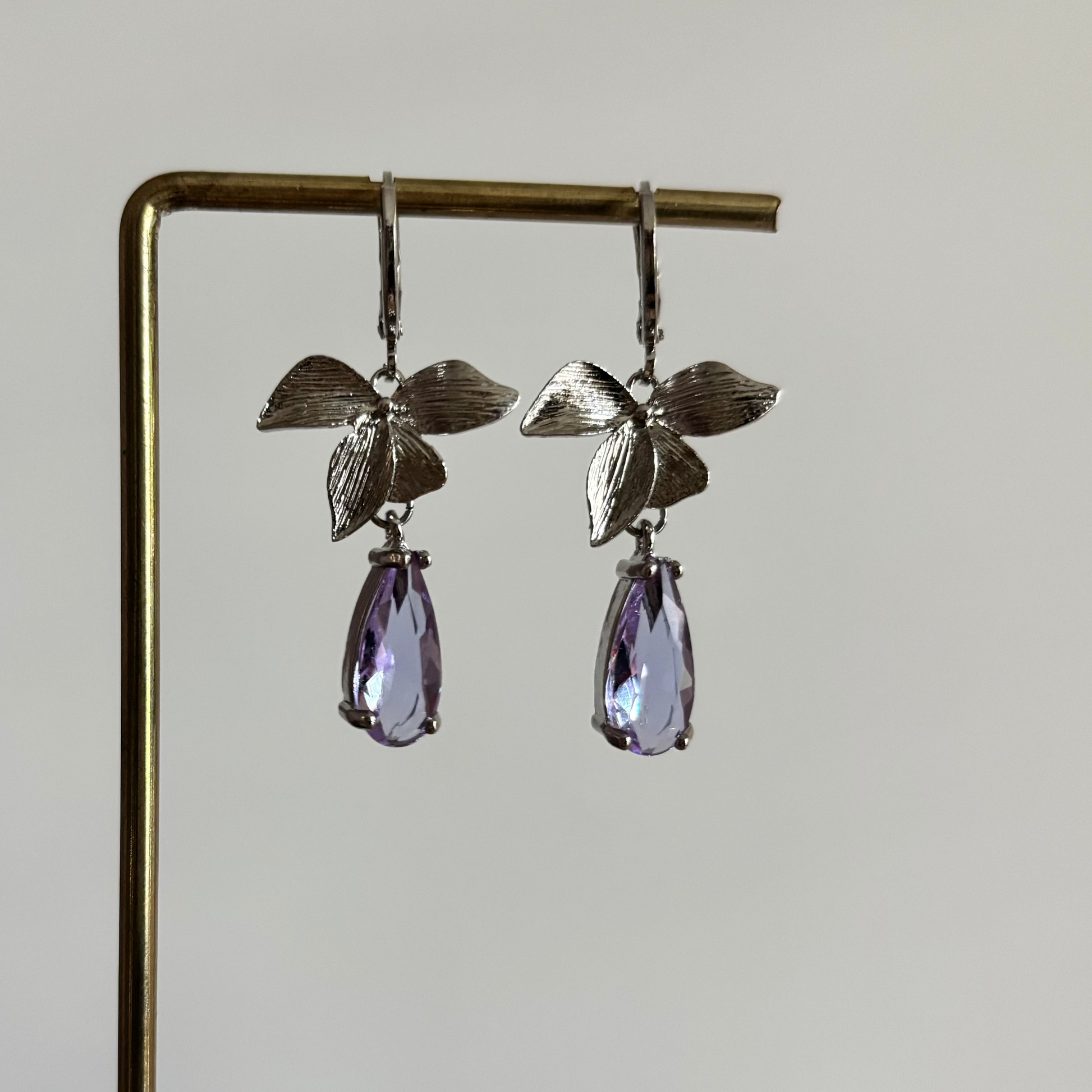 Zilverkleurige oorbellen Blossom bestaande uit ronde oorringen met hangende zilveren blaadjes en een gekleurde glasbedel.