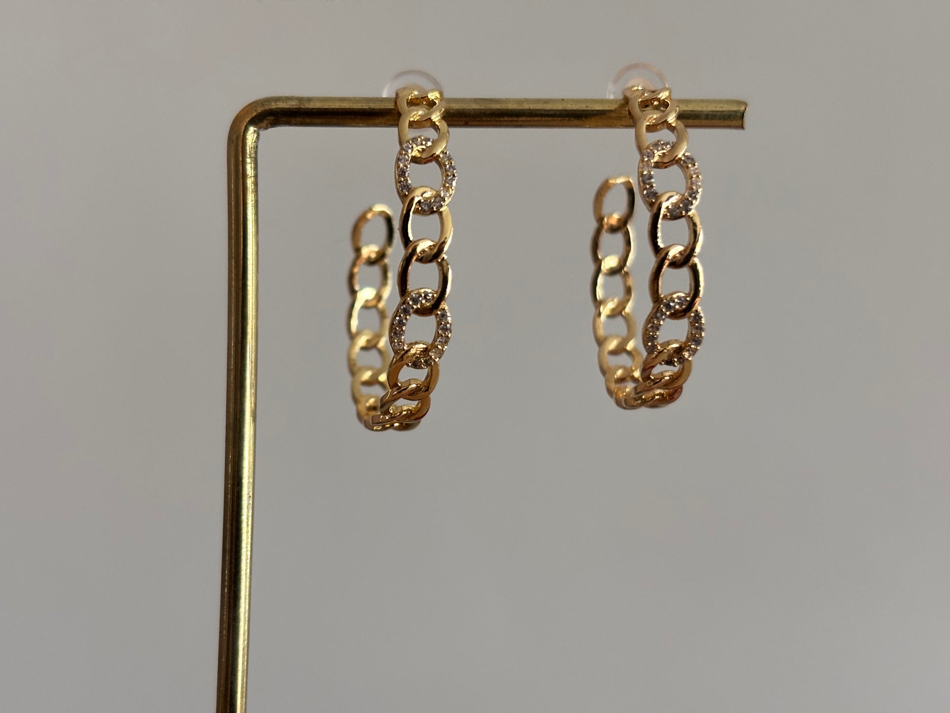 Open hoop oorbel Bo van 18k verguld goud met een bewerkte ring, lichtgewicht en modern van uitstraling.