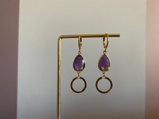 Korte oorbel met diep paarse peervormige steen met bladgoud en kleine gehamerde cirkel, circa 3 cm lang.