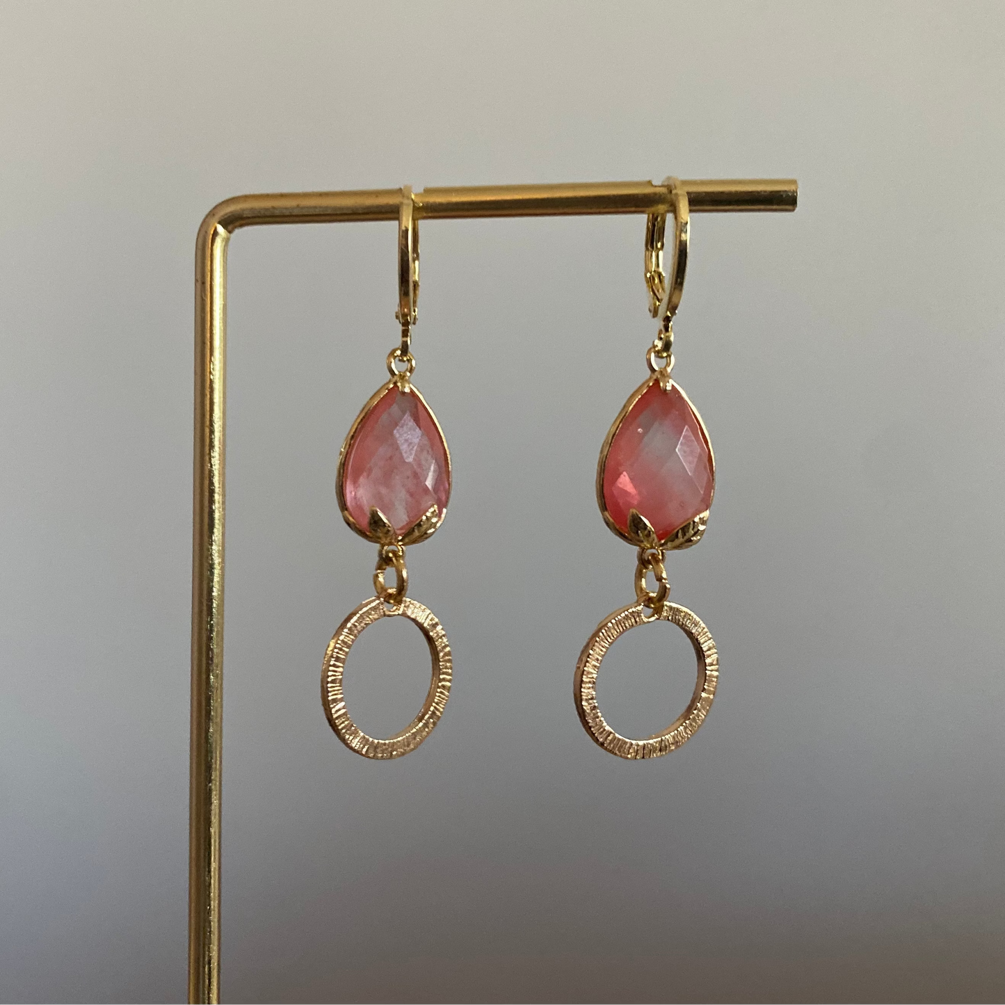 Korte oorbel met roze peervormige steen met bladgoud en kleine gehamerde cirkel, circa 3 cm lang.