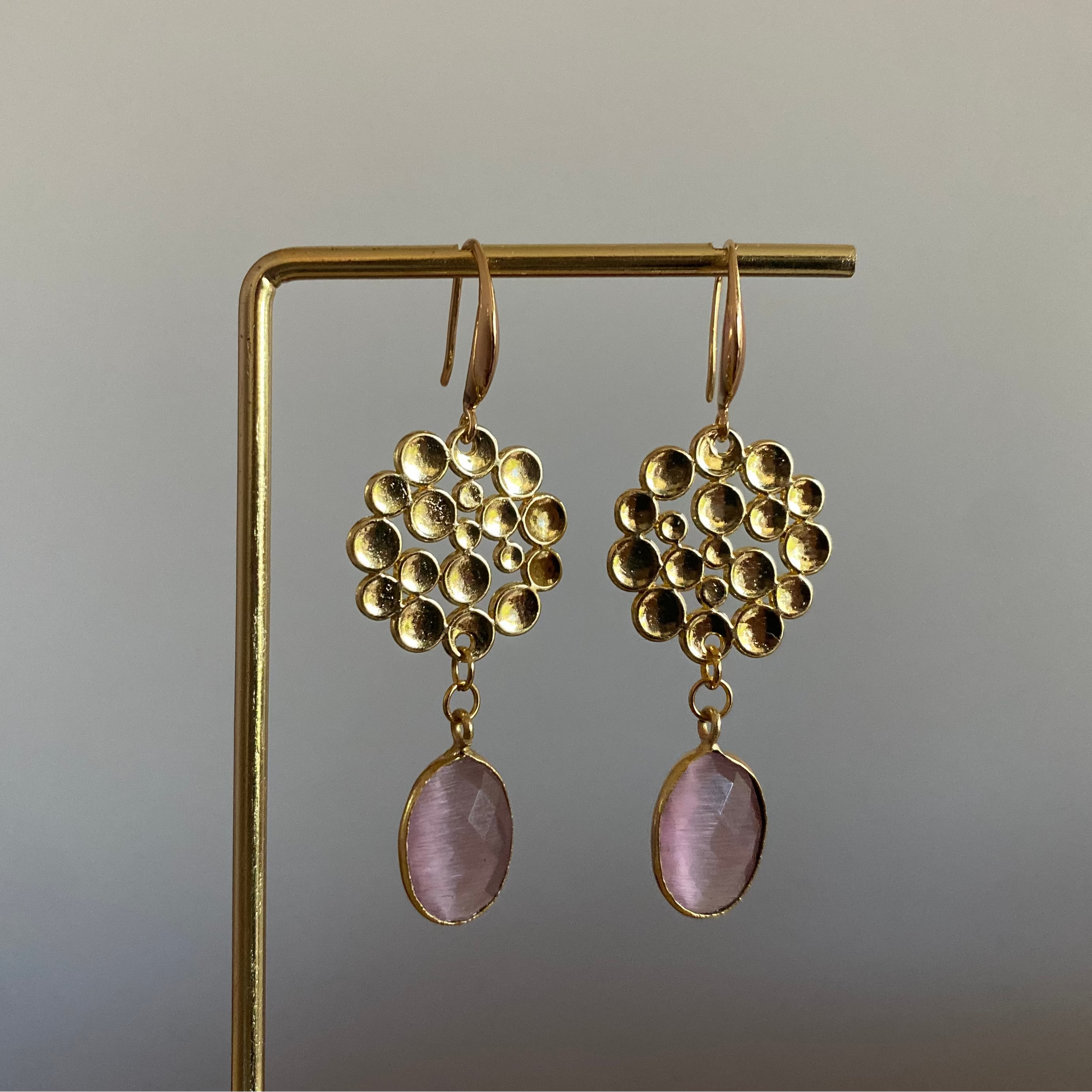 Oorbel met 14k vergulde bubbelhanger en daaronder een ovale roze catseye steen.