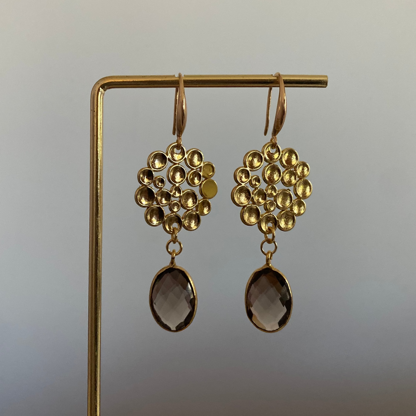 Oorbel met 14k vergulde bubbelhanger en daaronder een ovale taupe kleurige steen.