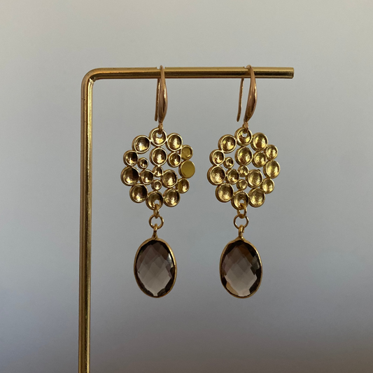 Oorbel met 14k vergulde bubbelhanger en daaronder een ovale taupe kleurige steen.