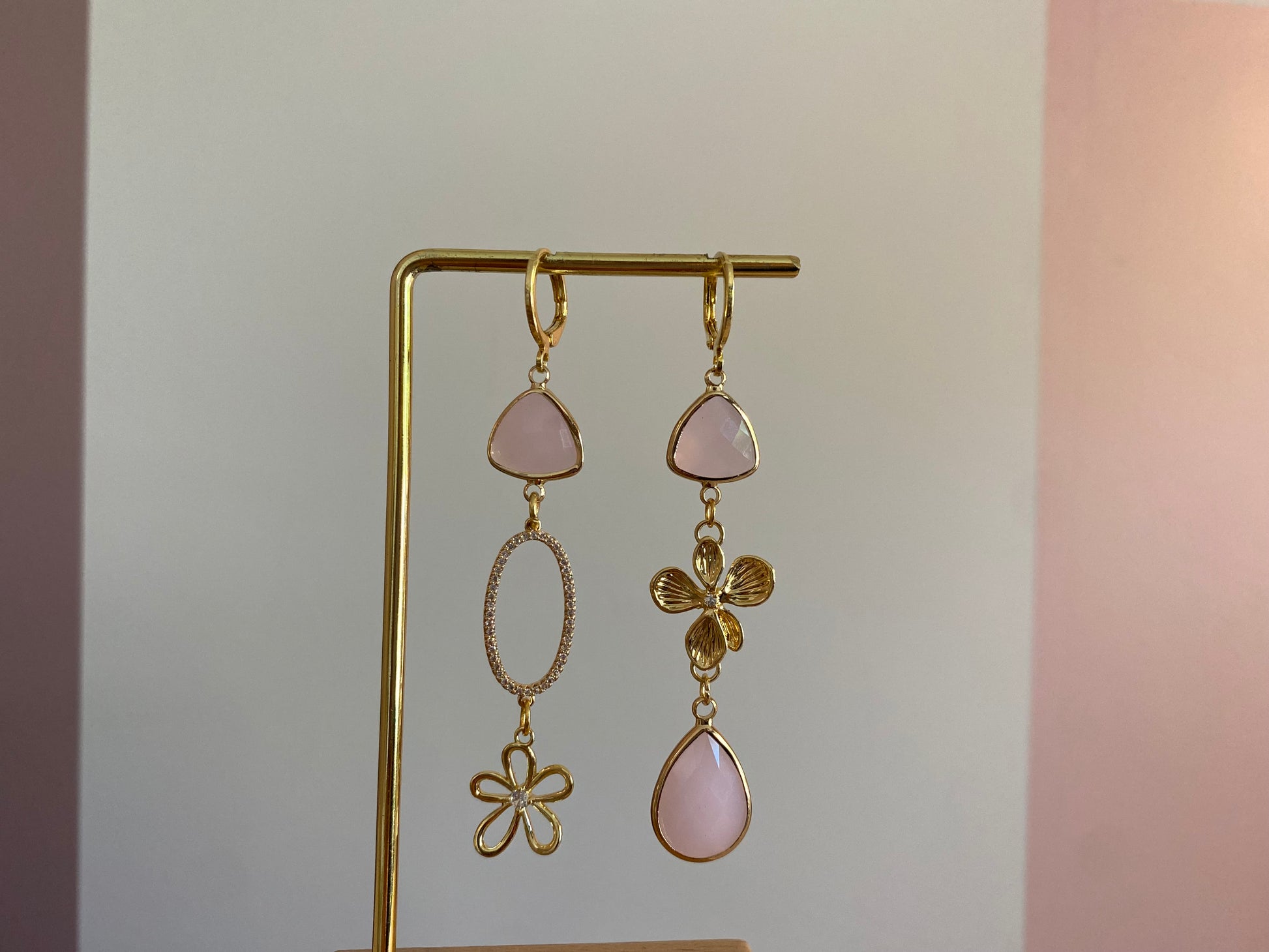 Asymmetrisch paar met 14K vergulde bloemen, een ovalen zirkonia hanger en mat zachtroze gladbedels