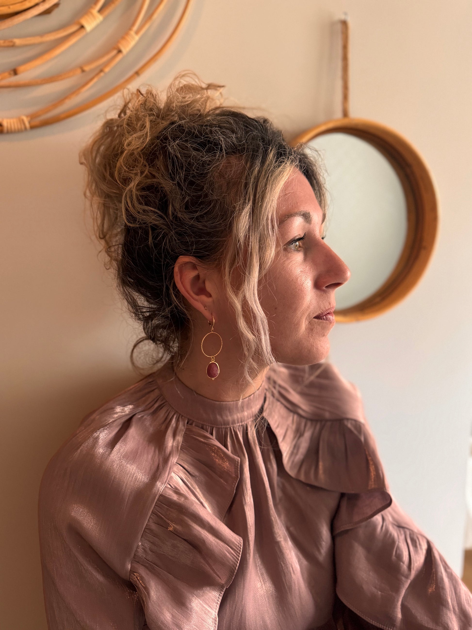 Model met Asymmetrisch paar met rodoniet of labradoriet natuurstenen bedels en 14K vergulde gouden hangers.