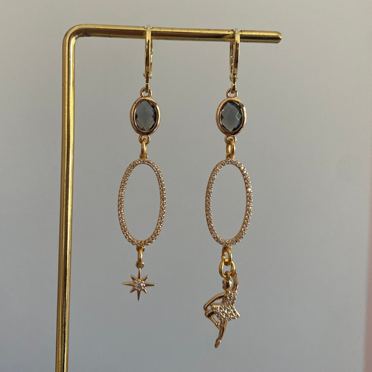 Model met Handgemaakte asymmetrisch paar met  14k vergulde oorbellen met grijze glasbedels, hangers met zirkonia en een zirkonia danseres en ster 