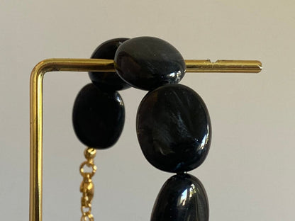 Handgemaakte en verstelbare armband in zwarte acryl kralen, afgewerkt met een hoogwaardige stainless steel sluiting 