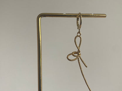 Handgemaakte earparty oorbel met een 14K verguld oorringetje en een stainless steel opengewerkte strik
