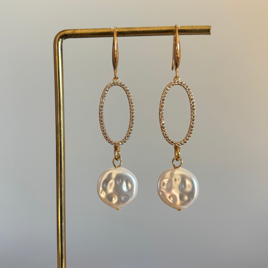 "14k vergulde oorbellen met een zirkonia ingezette ovale ring en een grote witte barokparel hanger."