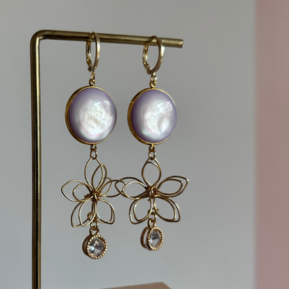 Symmetrische 14k gouden oorbellen met lila glitterstenen, zirkonia en gouden draadbedels in bloemvorm.