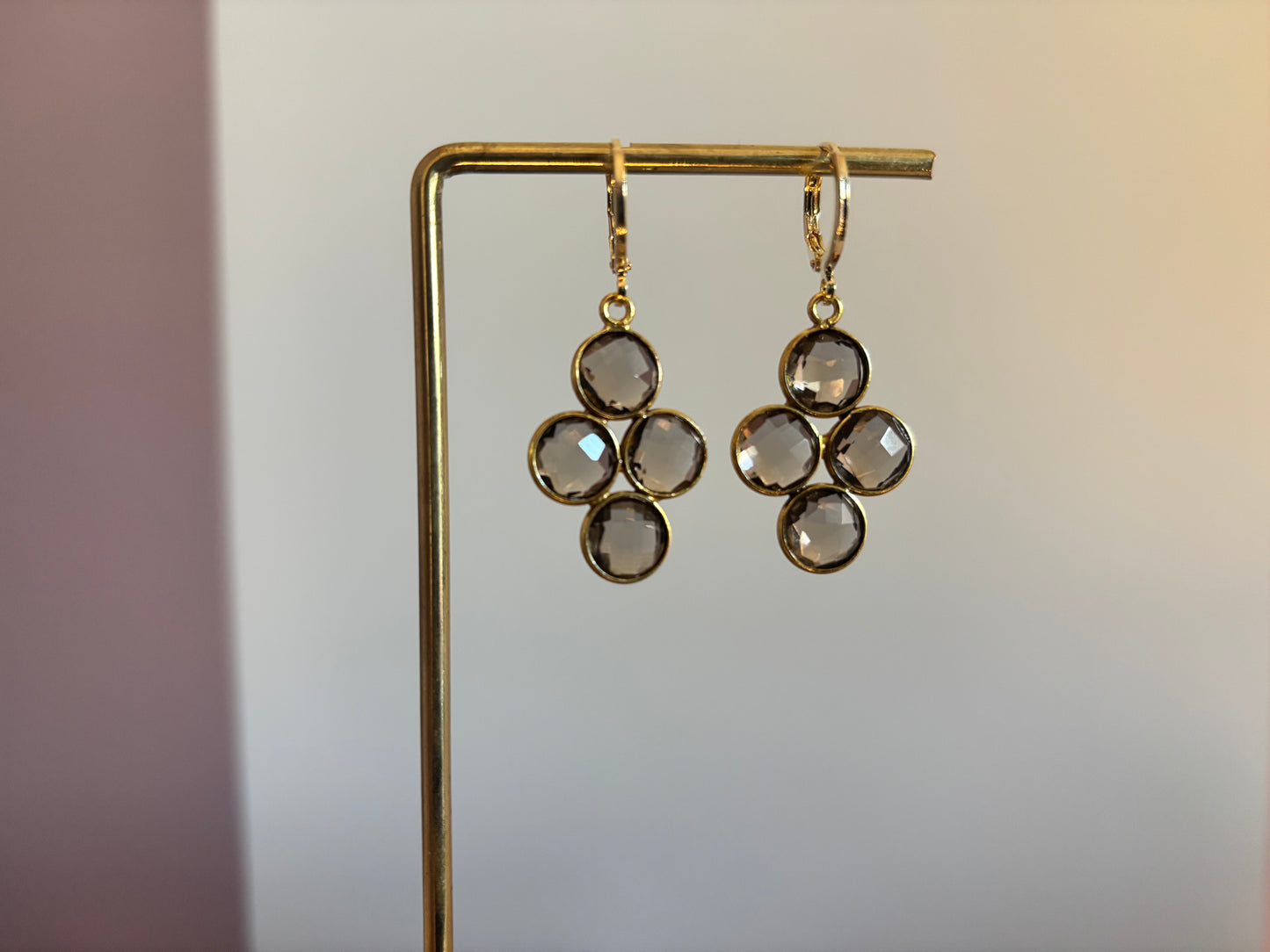 Kleine gouden oorbellen met een ronde taupekleurige steen die verdeeld is in vier gelijke vlakken