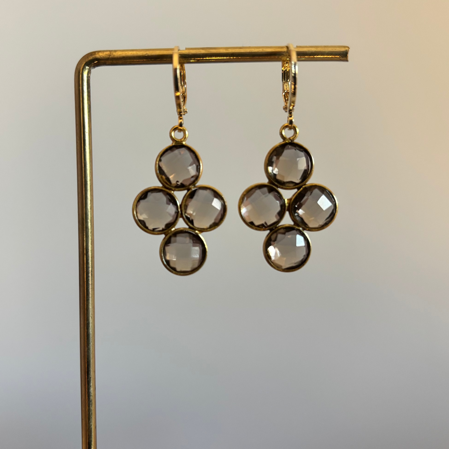 Kleine gouden oorbellen met een ronde taupekleurige steen die verdeeld is in vier gelijke vlakken