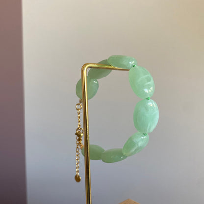 Handgemaakte en verstelbare armband met zeegroene opvallende acrylkralen afgewerkt met stainless steel kettinkje.