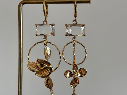 Asymmetrische 14K vergulde oorbellen met glazen bedels en gouden bloem- en bladmotieven.