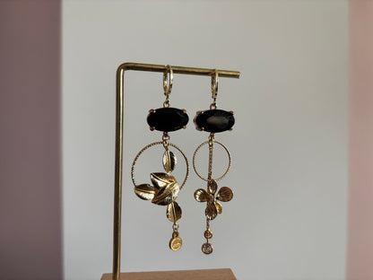 Asymmetrische 14K vergulde oorbellen met glazen bedels en gouden bloem- en bladmotieven.