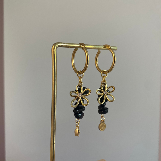 Handgemaakte vergulde gouden oorbellen bestaande uit RVS hoops met daaraan zwarte natuurstenen met een 14K vergulde bloembedel met ingelegde zirkonia.