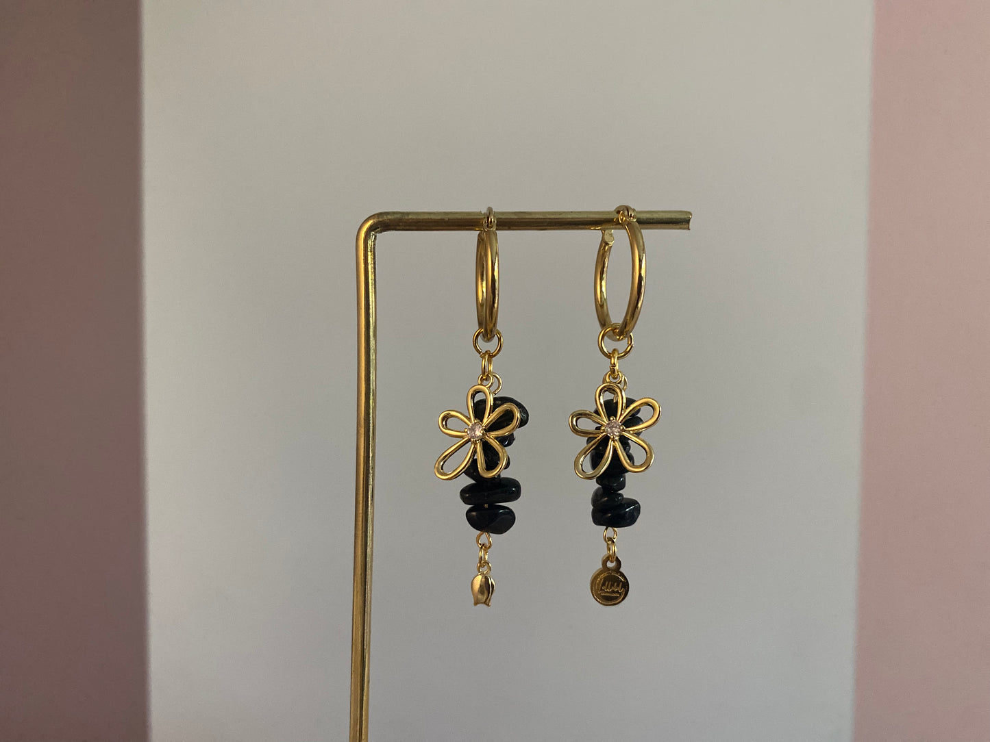 Handgemaakte vergulde gouden oorbellen bestaande uit RVS hoops met daaraan zwarte natuurstenen met een 14K vergulde bloembedel met ingelegde zirkonia.