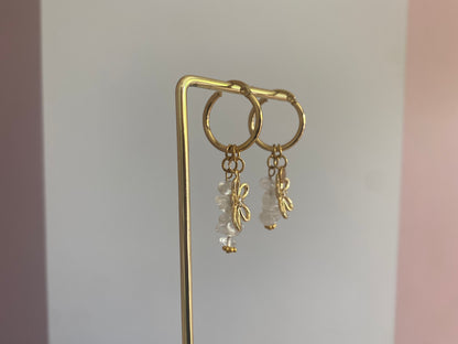 foto van de zijkant van andgemaakte vergulde gouden oorbellen bestaande uit RVS hoops met daaraan witte en zachtroze natuurstenen met een 14K vergulde bloembedel met ingelegde zirkonia.