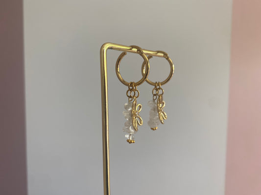 foto van de zijkant van andgemaakte vergulde gouden oorbellen bestaande uit RVS hoops met daaraan witte en zachtroze natuurstenen met een 14K vergulde bloembedel met ingelegde zirkonia.