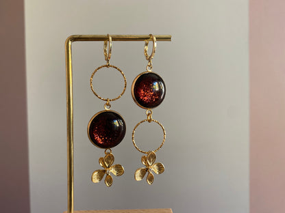 Asymmetrische 14k vergulde oorbellen met roodbruine glitter cabochon en zwarte glassteen — feestelijke variant van het populaire model Annick