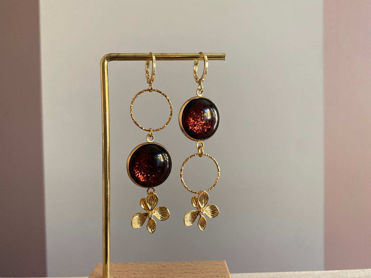 Asymmetrische 14k vergulde oorbellen met roodbruine glitter cabochon en zwarte glassteen — feestelijke variant van het populaire model Annick