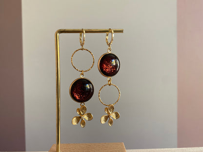 Asymmetrische 14k vergulde oorbellen met roodbruine glitter cabochon en zwarte glassteen — feestelijke variant van het populaire model Annick