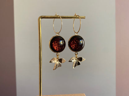 Symmetrische 14k vergulde oorbellen met roodbruine glitter cabochon, minimalistische ring en bladaccent — feestelijke en elegante uitstralin