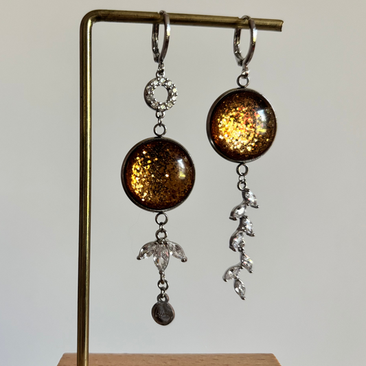 "Mismatched zilveren oorbellen Glow Marie met ronde bronskleurige glitter cabochons, zirkonia cirkel en strass-takje."