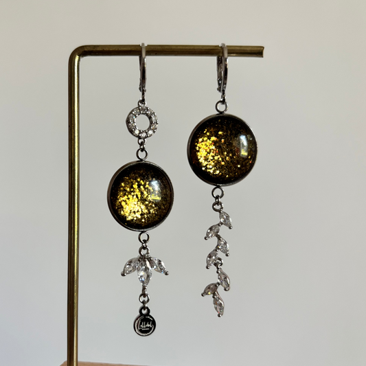 "Mismatched zilveren oorbellen Glow Marie met ronde olijfgroene glitter cabochons, zirkonia cirkel en strass-takje."