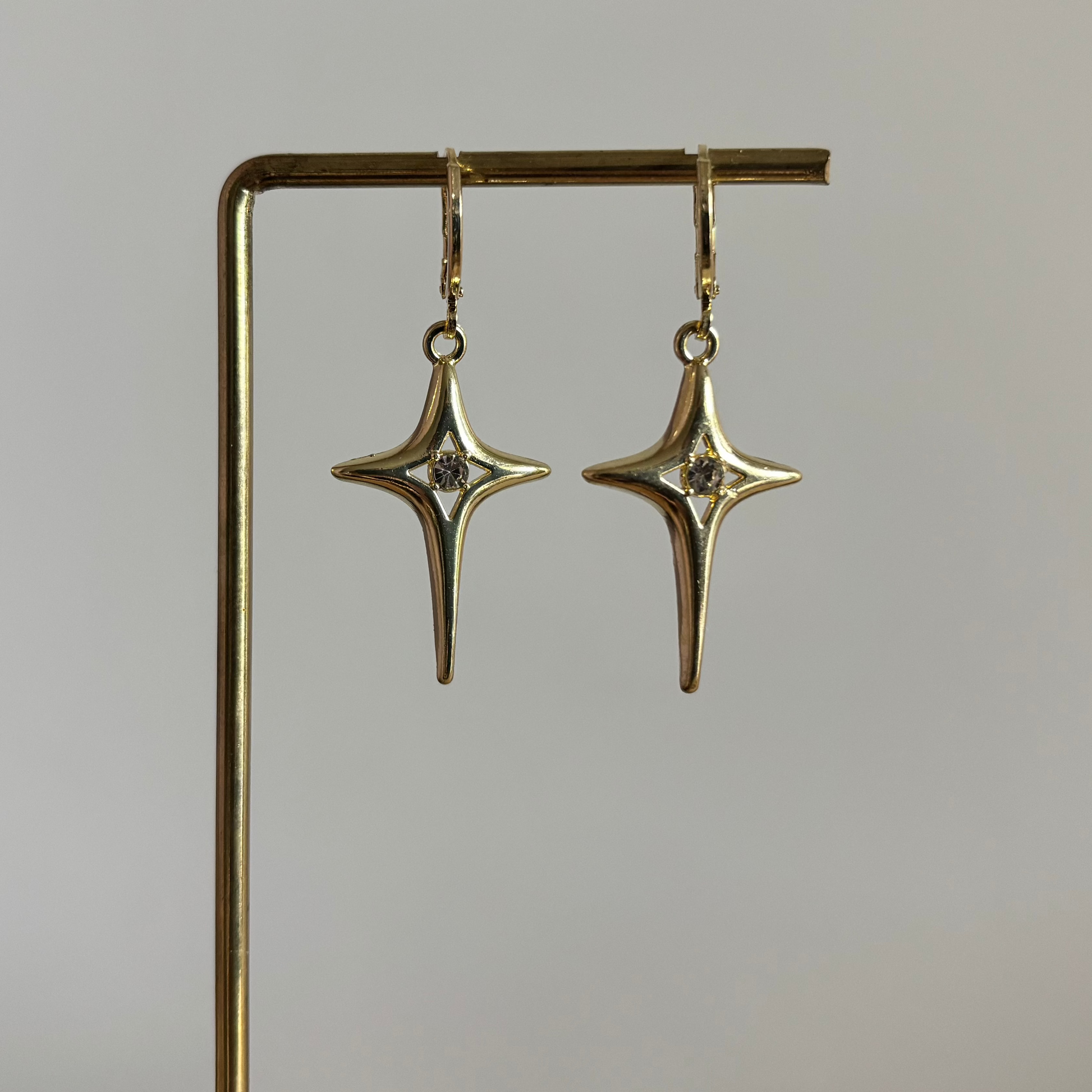 Gouden 14k vergulde oorbellen met geometrische sterbedels en zirkonia steentje.