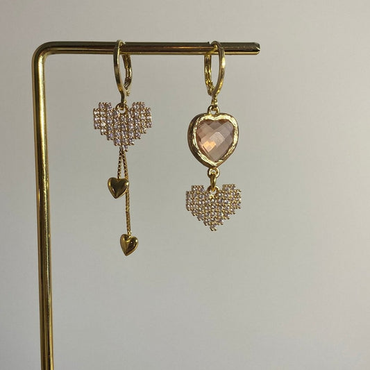Asymmetrisch handgemaakt paar met 14k vergulde gouden materialen waaronder kleine hangende hartjes, zirkonia hartjes en een champagne glasbedel.