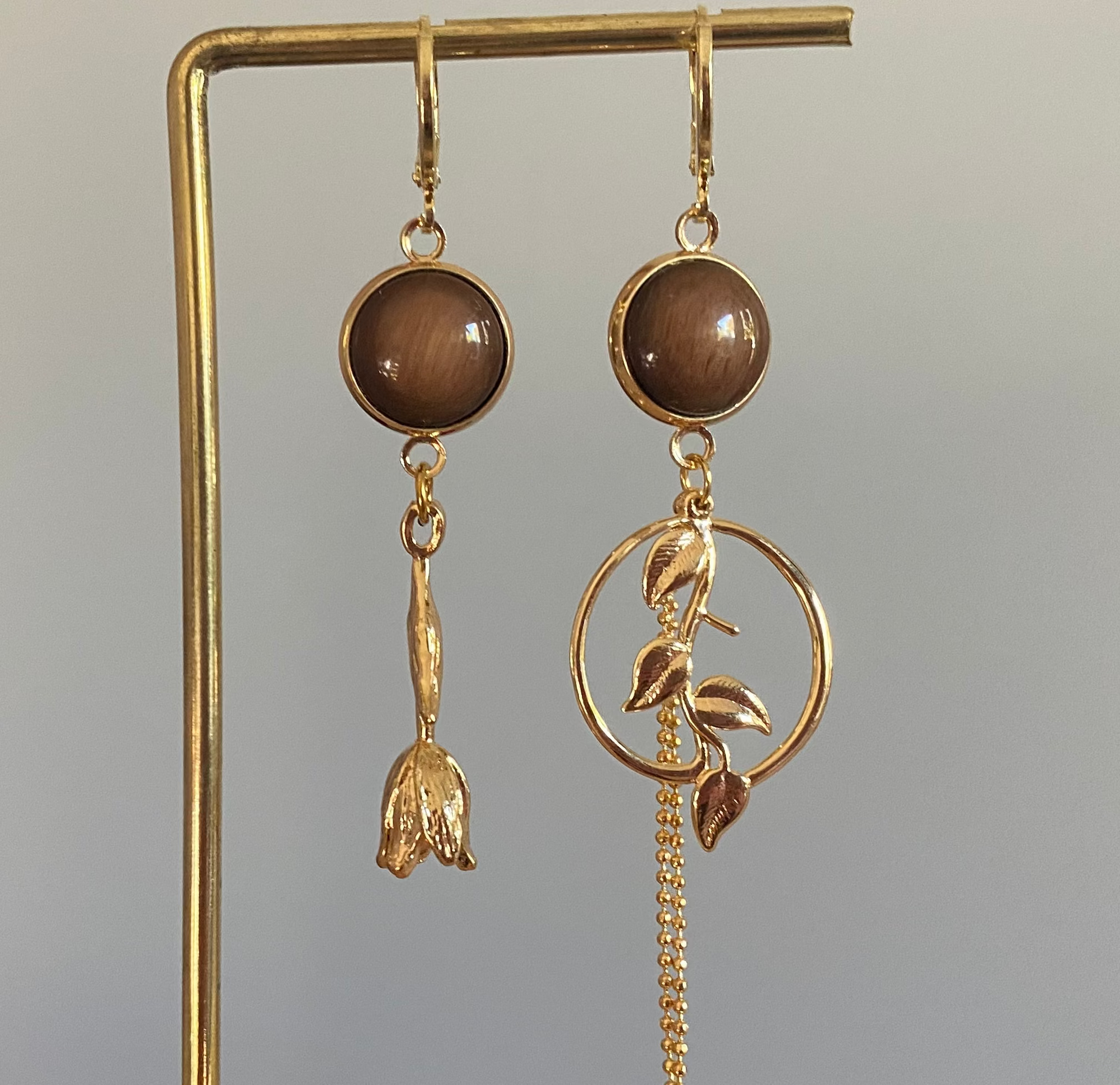 Asymmetrisch mismatch paar met een donkerbruine cabochon en 14k vergulde Roos, rechts donkerbruine cabochon, blad bedel en verguld kwastje