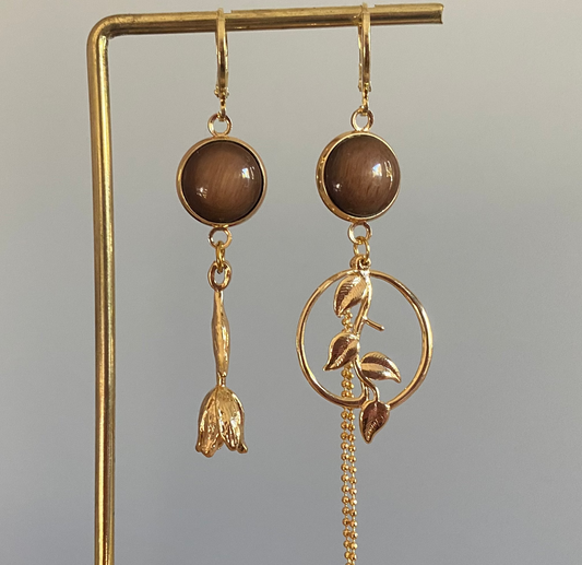 Asymmetrisch mismatch paar met een donkerbruine cabochon en 14k vergulde Roos, rechts donkerbruine cabochon, blad bedel en verguld kwastje