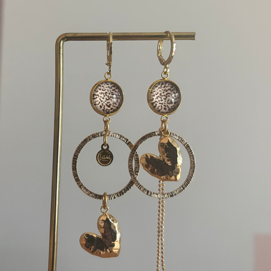 Asymmetrische 14k vergulde oorbellen Ivy met panterprint cabochon, gehamerde ringen, hartvormige bedel en kwastje, circa 6 cm lang