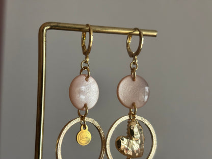 Asymmetrische 14k vergulde oorbellen Ivy met parelmoer zachtroze cabochon, gehamerde ringen, hartvormige bedel en kwastje, circa 6 cm lang