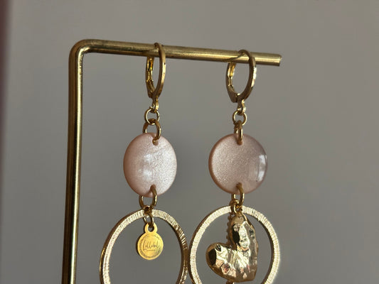 Asymmetrische 14k vergulde oorbellen Ivy met parelmoer zachtroze cabochon, gehamerde ringen, hartvormige bedel en kwastje, circa 6 cm lang