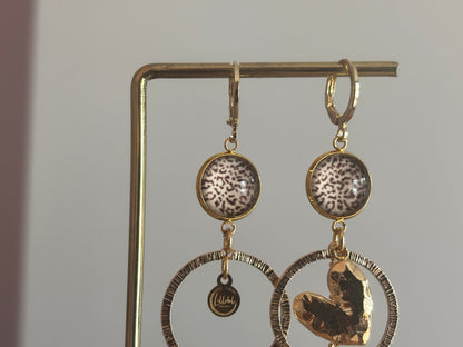 Asymmetrische 14k vergulde oorbellen Ivy met panterprint cabochon, gehamerde ringen, hartvormige bedel en kwastje, circa 6 cm lang