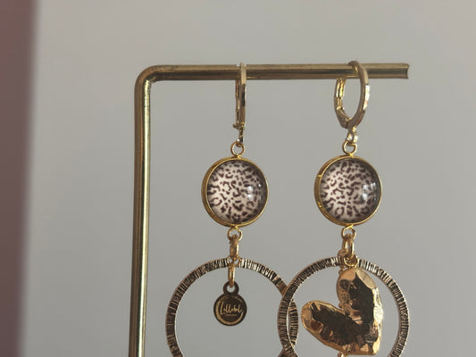 Asymmetrische 14k vergulde oorbellen Ivy met panterprint cabochon, gehamerde ringen, hartvormige bedel en kwastje, circa 6 cm lang