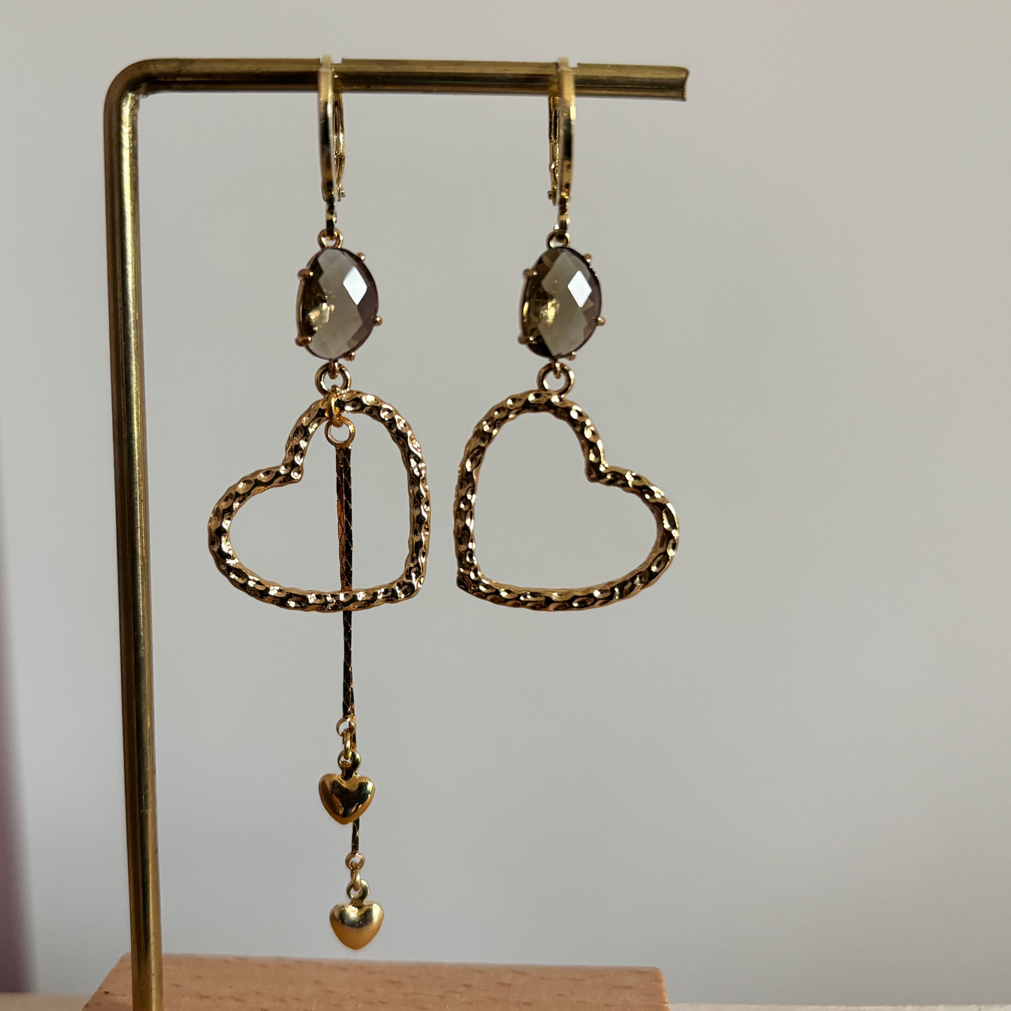 Asymmetrische gouden oorbellen Jet met gehamerde harten en taupe glas.