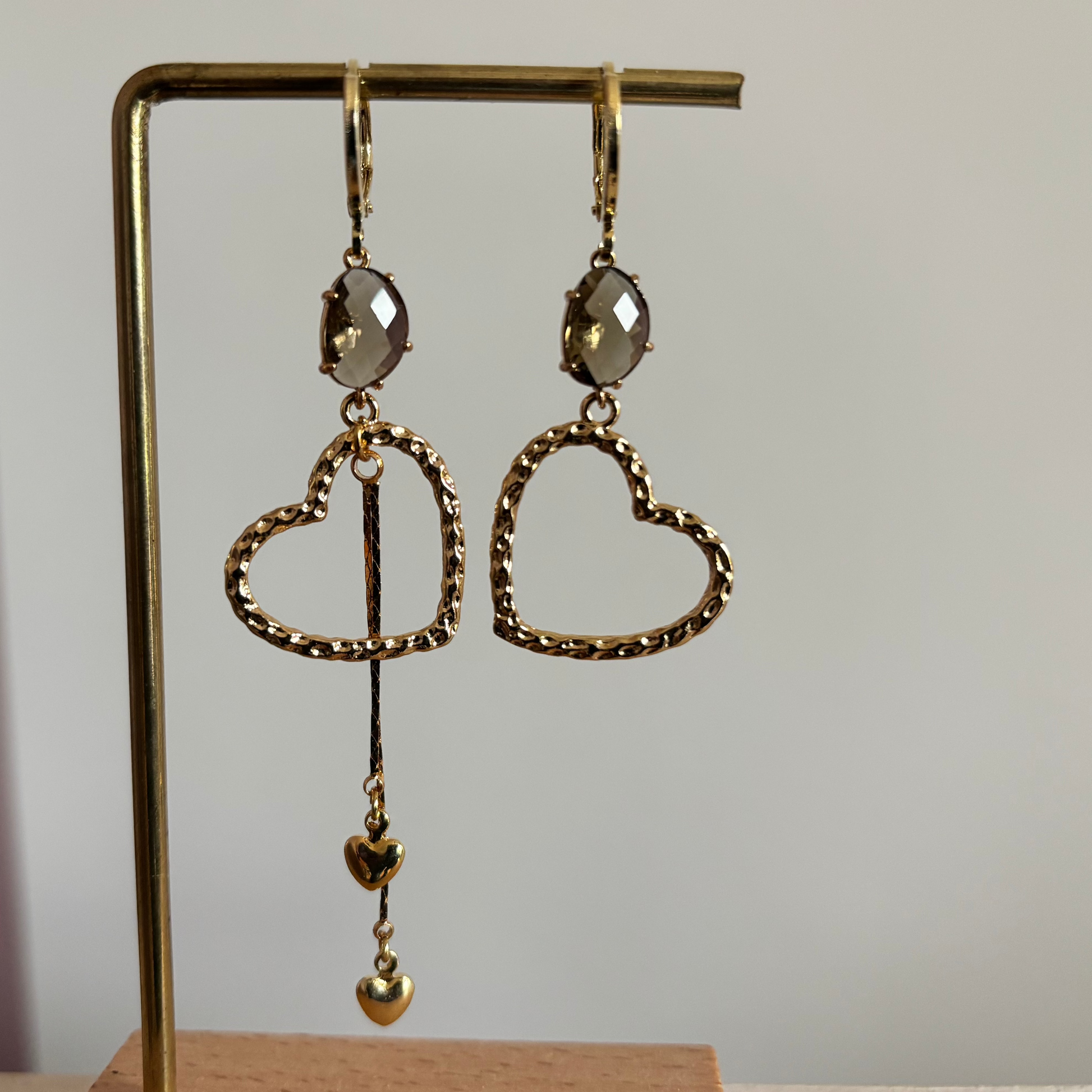 Asymmetrische gouden oorbellen Jet met gehamerde harten en taupe glas.