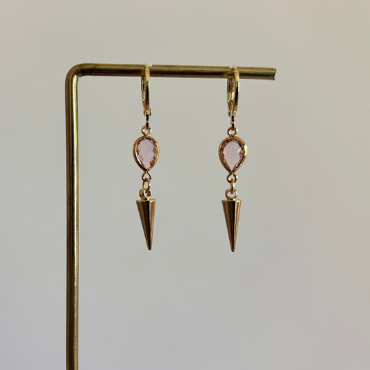 Goudkleurige oorbellen met een kleine roze druppelvormige steen en een hangende goudkleurige spike bedel."