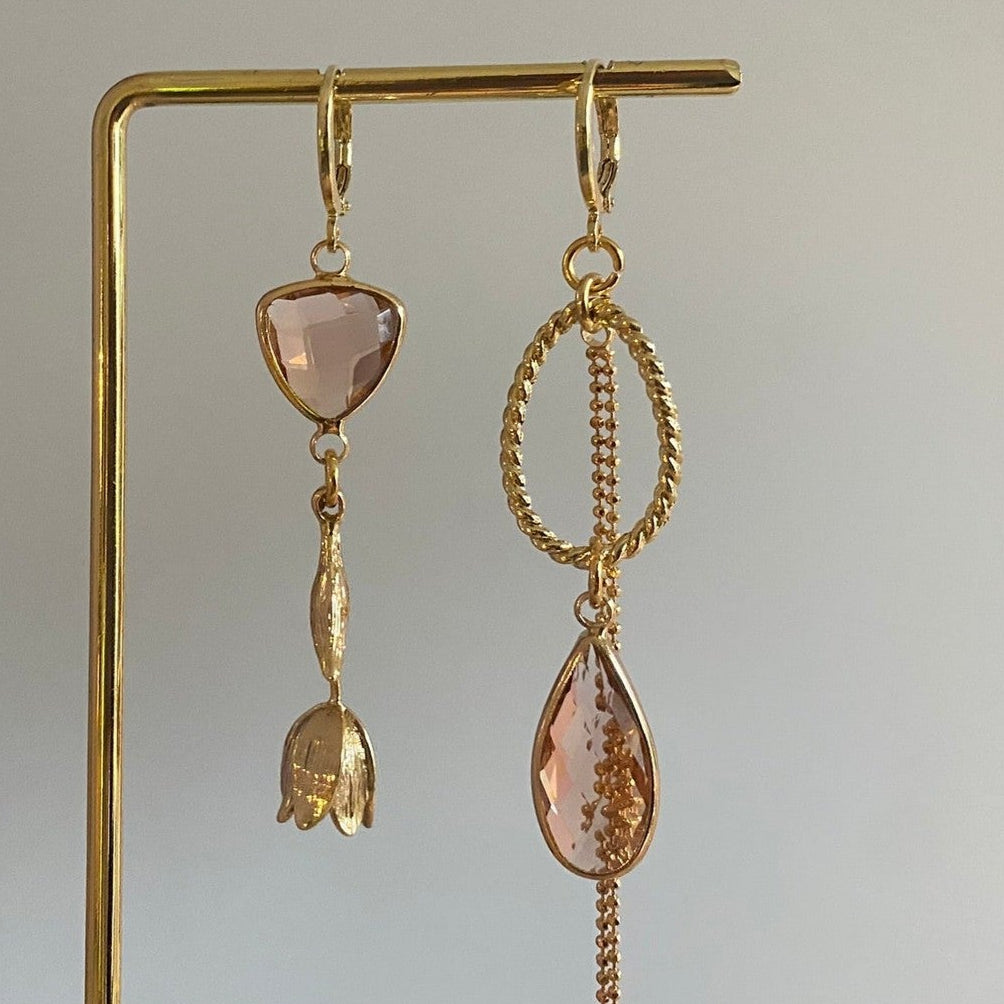 Asymmetrisch handgemaakt paar met 14k vergulde gouden materialen waaronder een gedraaide hanger en een tulp en glasbedels in de kleur champagne