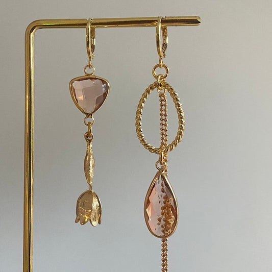 Asymmetrisch handgemaakt paar met 14k vergulde gouden materialen waaronder een gedraaide hanger en een tulp en glasbedels in de kleur champagne