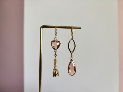 Asymmetrisch handgemaakt paar met 14k vergulde gouden materialen waaronder een gedraaide hanger en een tulp en glasbedels in de kleur champagne