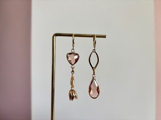 Asymmetrisch handgemaakt paar met 14k vergulde gouden materialen waaronder een gedraaide hanger en een tulp en glasbedels in de kleur champagne