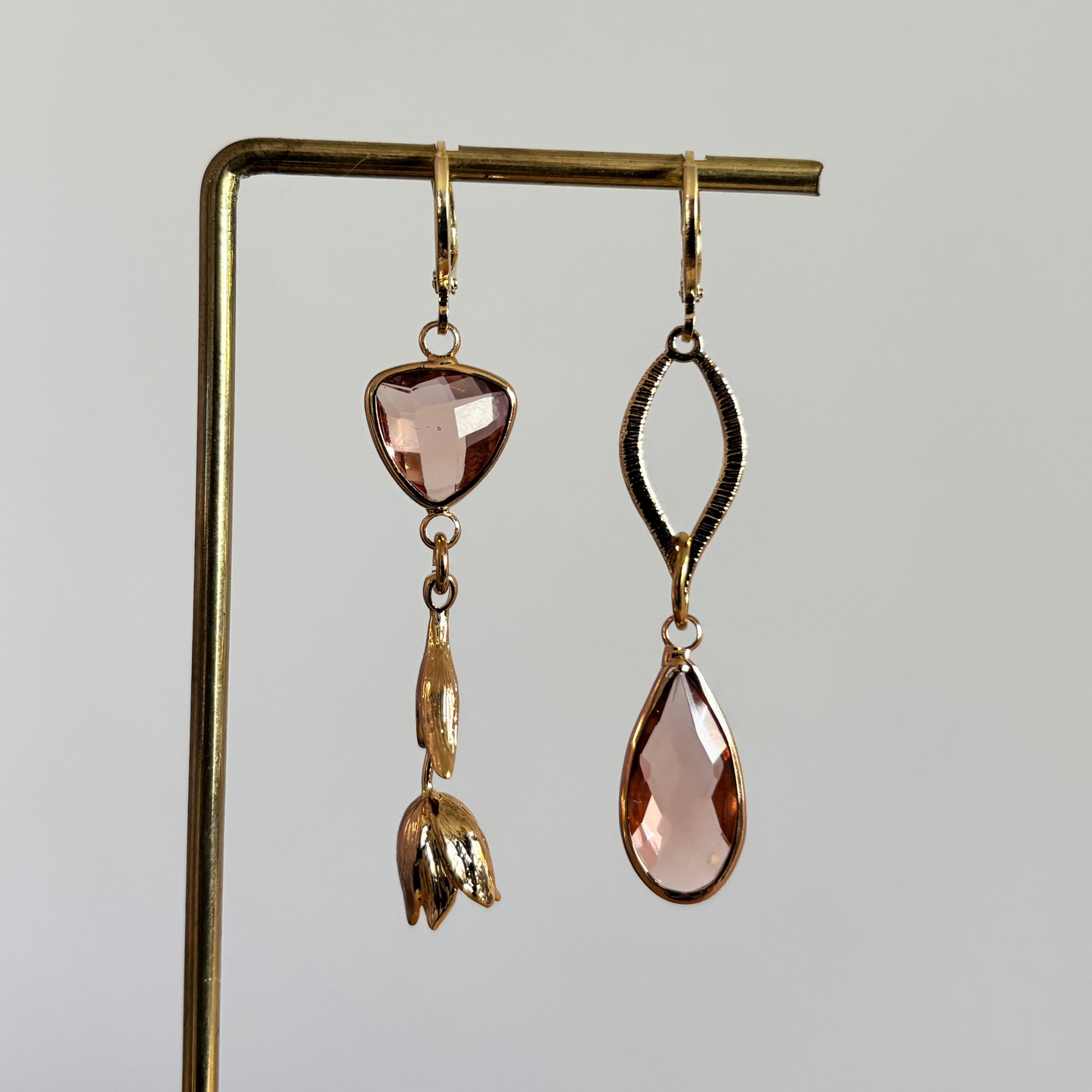 Asymmetrisch handgemaakt paar met 14k vergulde gouden materialen waaronder een gedraaide hanger en een tulp en glasbedels in de kleur champagne